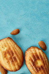 Yummy almond cookies arranged on blue background, close-up, selective focus, top view.
