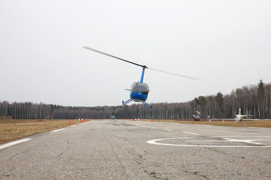 Aircraft - Blue small helicopter makes flight at low height