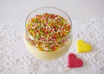 Dessert vanilla creme in glass with colored sprinkles on the top