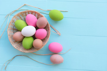 Colorful easter egg on blue pastel color wood background with space.