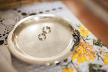 Two silver wedding rings on bowl inside church  light , closeup image