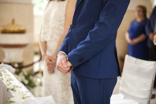 Closeup image of bridegrooms hands on marriage ceremony inside church