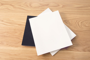 Blank white stacking magazine cover on wooden table background.