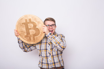 Happy business man holding big golden bitcoin on white background. Crypto currency, virtual money, internet and economics concept