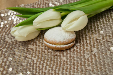 Fototapeta na wymiar white spring tulips on a beige shiny background