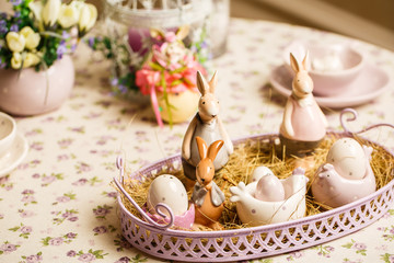 Porcelain Easter bunnys or rabbits with eggs on the table