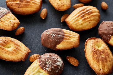 Freshly baked almond cookies on stone board over wooden background, top view, selective focus.