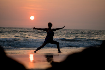 Fototapeta na wymiar Yoga silhouette at ocean cost and sunset India