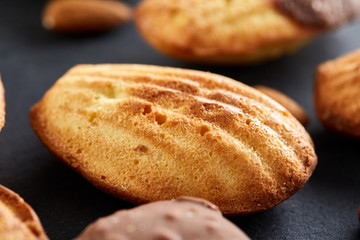 Freshly baked almond cookies on stone board over wooden background, top view, selective focus.