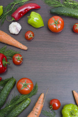 Vegetables concept on a wooden background. Carrots with green and red pepper on the table. Fresh vegetables on a brown wooden background.