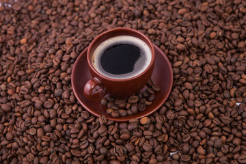 Cup of coffee on the coffee beans background