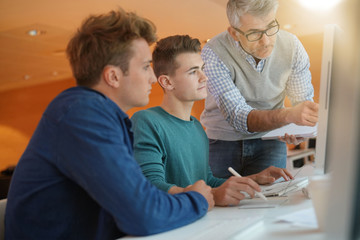 Obraz premium Teacher controlling students work in class