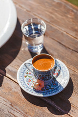 Turkish hot coffee in traditional painted cup top view on the table in cafe