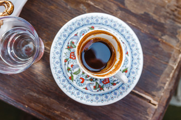 Turkish hot coffee in traditional painted cup top view on the table in cafe