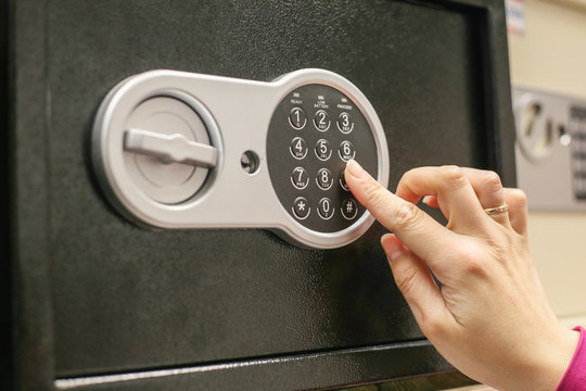 finger on digital lock of safe close up