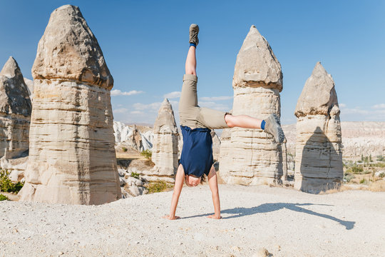 Young woman doing some acrobatic yoga exercises in valley of Cappadocia, Turkey