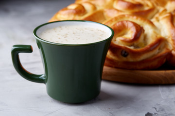 Homemade rose bread, cup of coffee, anise and cinnamon on white textured background, close-up, shallow depth of field
