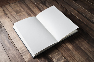 Blank open book, brochure or notebook on wooden table background. Responsive design mockup.