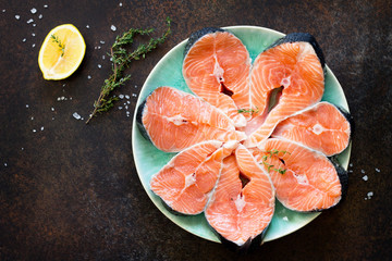 Fresh salmon on a dark stone table, preparation for cooking fish. Proper nutrition. Copy space, top view flat lay background.