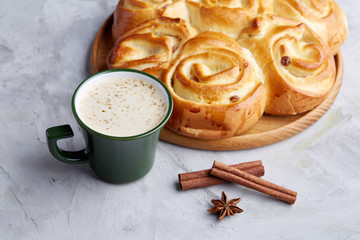 Homemade rose bread, cup of coffee, anise and cinnamon on white textured background, close-up, shallow depth of field
