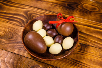Ceramic plate with chocolate easter eggs on wooden table
