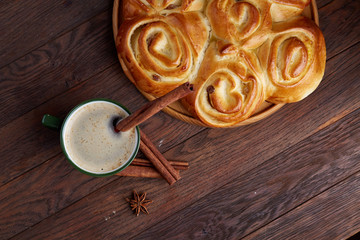 Homemade rose bread, cup of coffee, anise and cinnamon on vintage background, close-up, selective focus