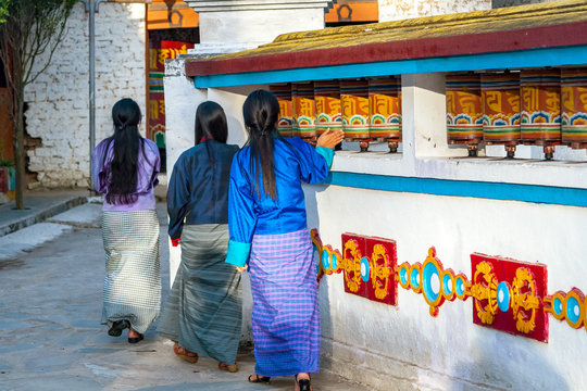 Local Bhutanese women turning prayer wheels in a Buddhist temple near Trashigang - Eastern Bhutan