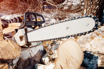 Chainsaw of lumberjack lie on sawn wood. concept is to cut trees at altitude.