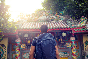 men backpacker looking at a temple in Bangkok , Thailand , Southeast asia .