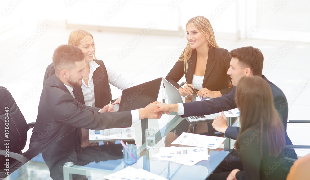 Sticker handshake of business partners sitting at your Desk