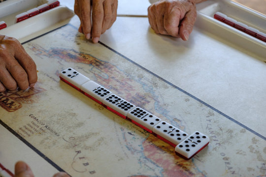 Men and woman of all ages play and compete against each other at one oc Cuba's favorite past time Dominoes
