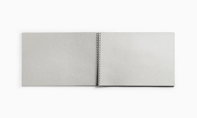 Photo of open sketchbook with blank pages on white paper background. Responsive design template....