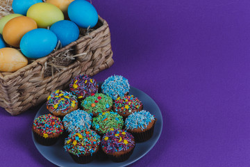 Easter eggs and Easter cupcakes in a basket. 