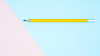 yellow pencil on blue and pink paper