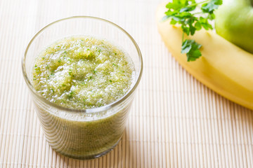 Green smoothies made from apples, parsley, banana in a glass on a light background. The concept of healthy eating. Weight Loss Drink