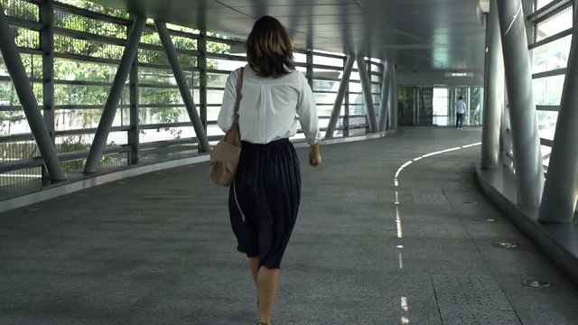 Businesswoman walking through tunnel in city, super slow motion 240fps
