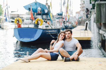 a loving couple hugs on a pier in a yacht club