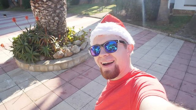 Young man in Santa's cap on vacation. Self portrait