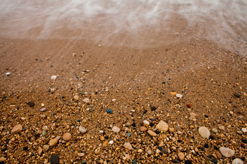 Sea background of sand. Textural background from sea small gravel, for your design.
