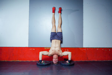 Young Man Athlete Doing Extreme Pushups Handstand As Part Of Bodybuilding Training