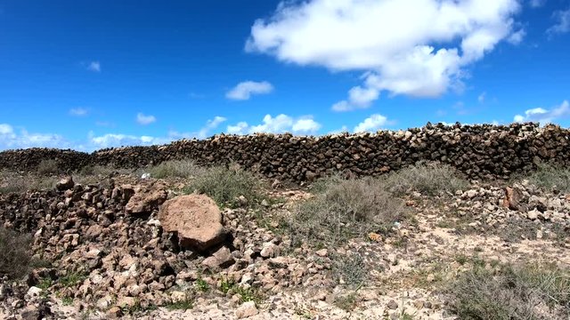 Vulkanlandschaft mit alter Steinmauer, Fahraufnahme, Fuerteventura, Kanaren, 4K
