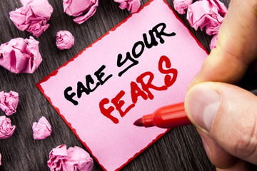 Text sign  Face Your Fears. Business concept for Challenge Fear Fourage Confidence Brave Bravery written Pin Sticky Note Paper Folded Paper the wooden background Man Holding Marker Hand