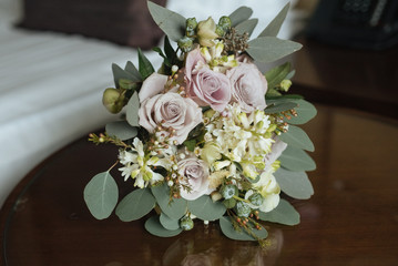 Beautiful pink flower wedding bouquet on wooden table near bed. Mornind bride and wedding decoration. Non usally style.