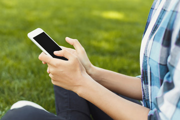 Unrecognizable woman using smartphone in park