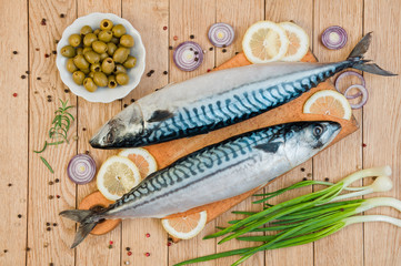 Fresh raw fish mackerel and ingredients for cooking on a wooden background in a rustic style