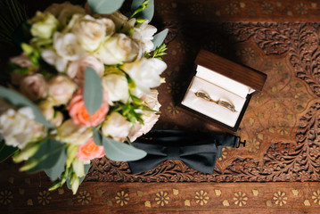 Wedding engagement rings and flowers wedding bouquet background, selective focus, macro