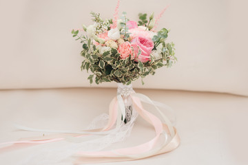Bridal morning details. Wedding bouquet of orange, beige and pink flowers with succulent