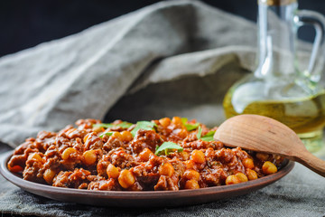 Chile with pork and chickpeas on a plate on dark background
