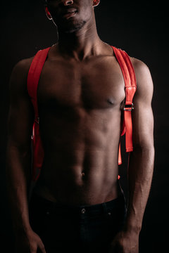 close up cropped Portrait of african nacked man's body with pick backpack. Travel concept.