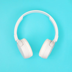 Headphones on modern blue pastel backgrounds. Top view, square. Trendy colorful photo. Music concept